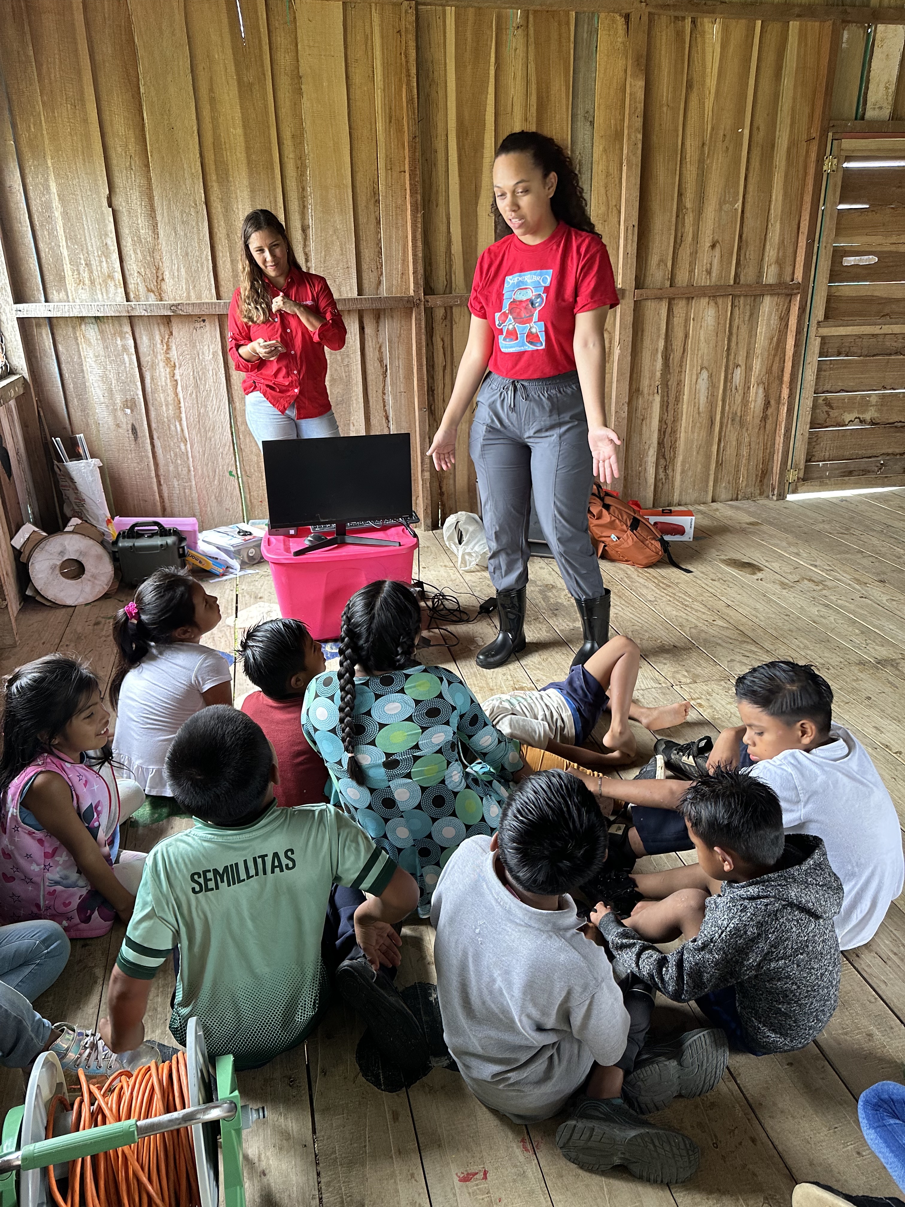 Two Superbook team members stand to teach a group of children in Alto Palmera.