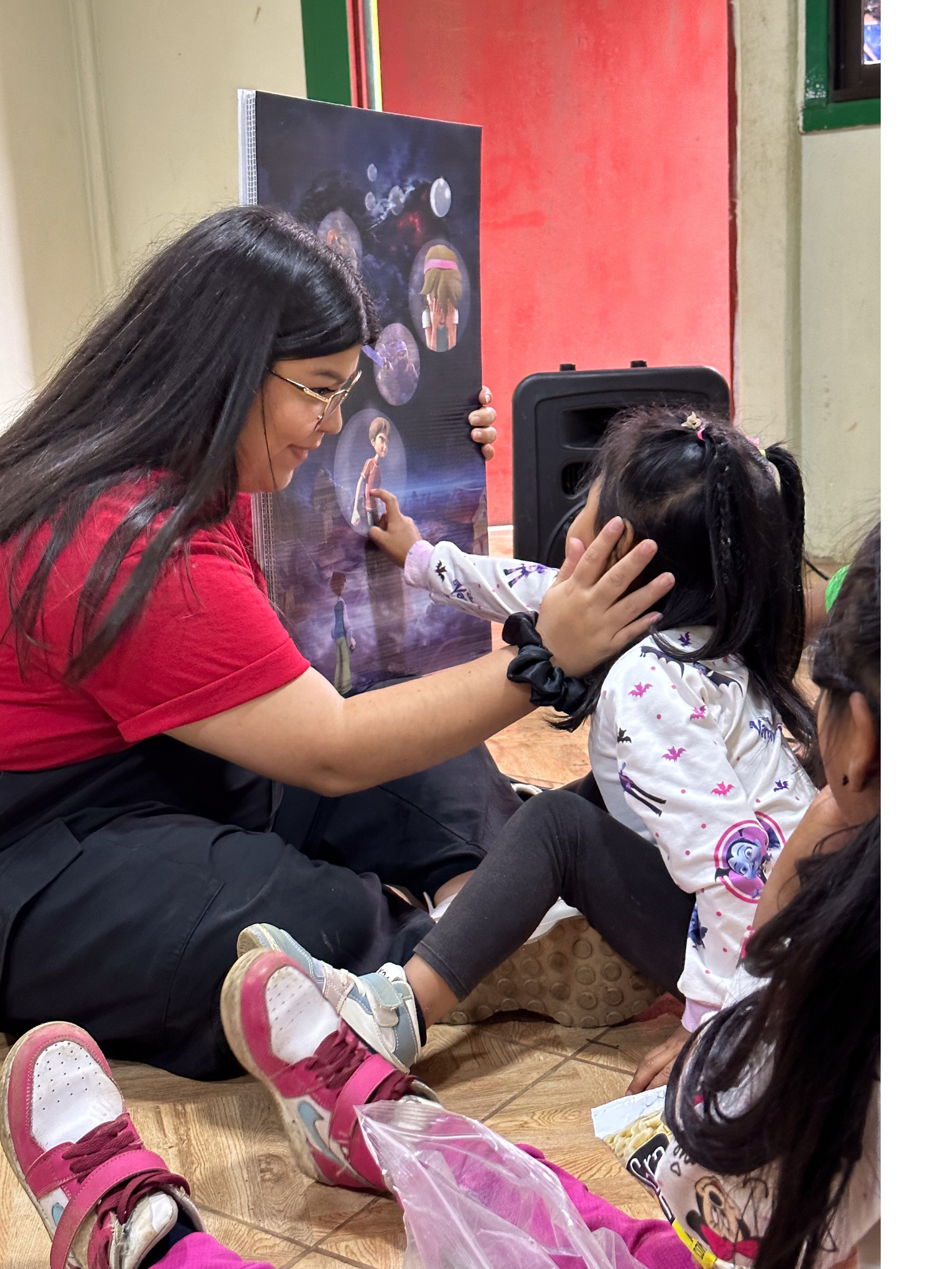 A Superbook team member uses a flip chart to explain the Gospel as a child reaches forward to touch the flip chart.