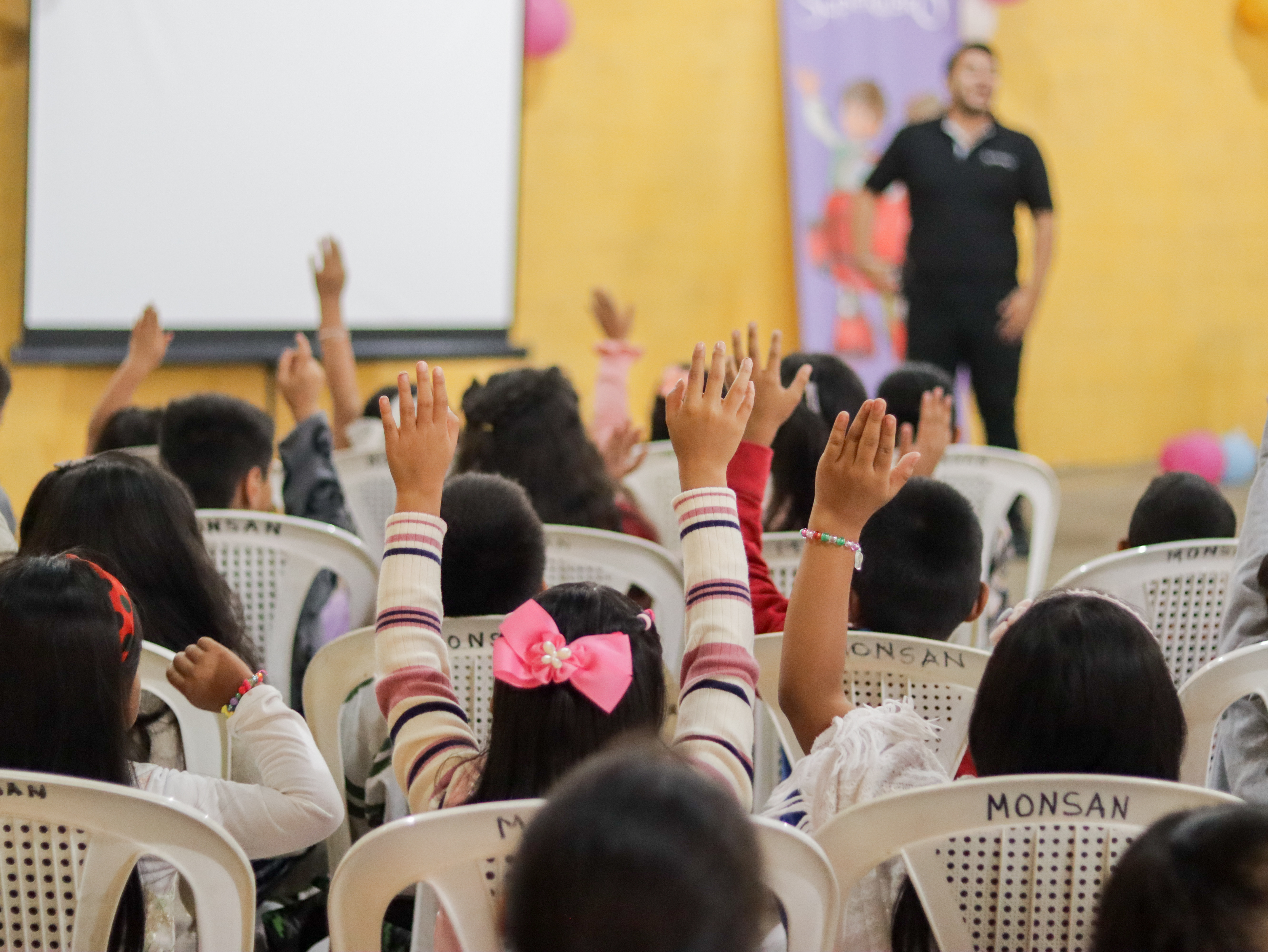 Children in Guatemala raise their hands to receive Jesus into their hearts.