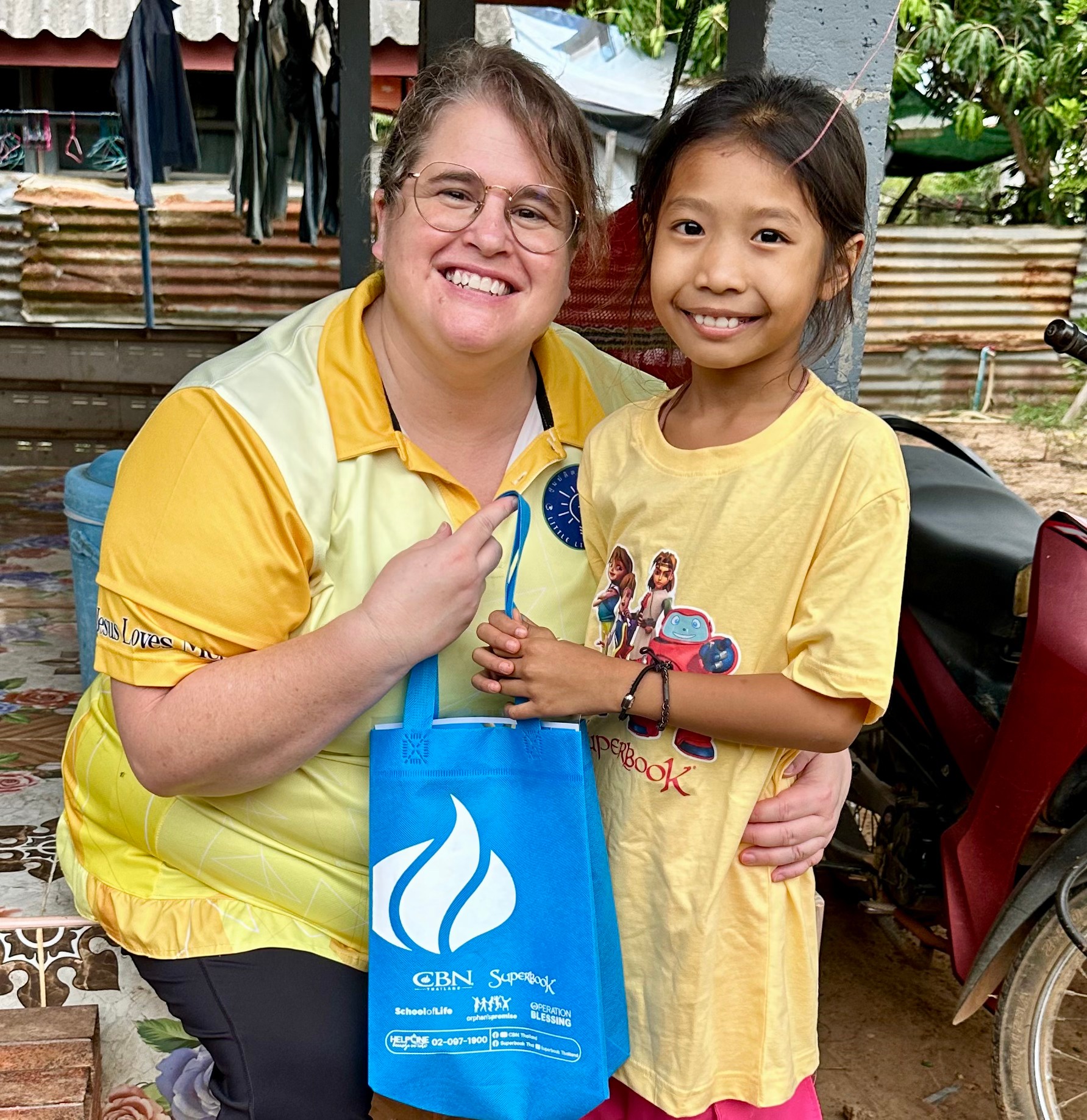 Phakwan and her Sunday School teacher smile outside of their church.