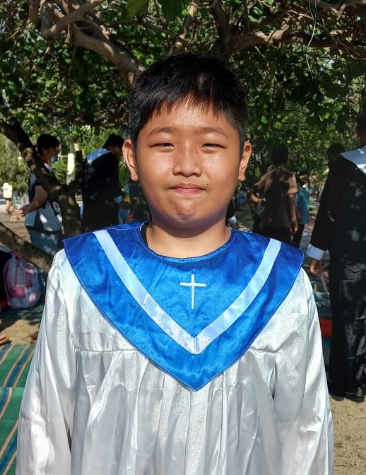 Mahmoud stands wearing his choir robe.