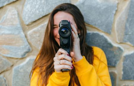 young woman filming with a video camera
