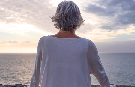 woman looking over the ocean at sunrise