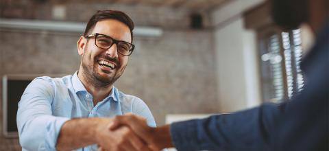 Men shaking hands in office environment