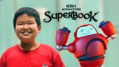 Danh, an 8-year-old boy in Vietnam, smiles at the camera. Gizmo stands behind him to the right, striking a strong man pose. The CBN Animation and Superbook logos are centered and stacked above them.