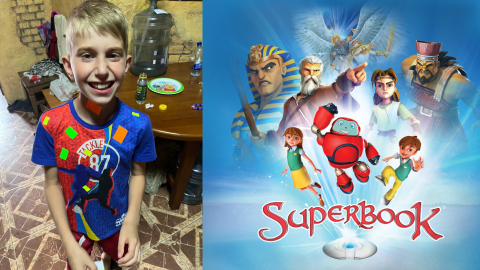 David, a 10-year-old boy from Ukraine, smiles at the camera next to a Superbook graphic with all the characters coming out of Superbook above the logo.