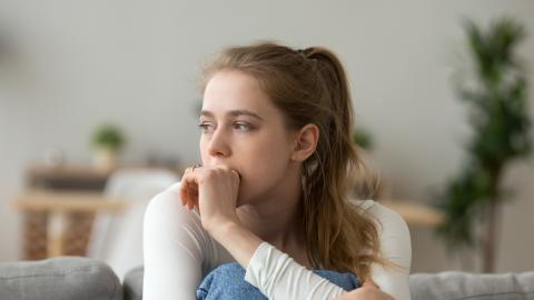 a woman deep in thought, appears anxious