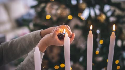 a woman lighting candles for advent and Christmas