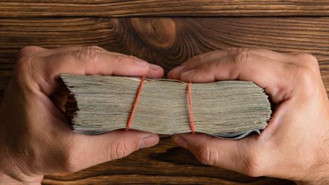 greedy hands holding onto money