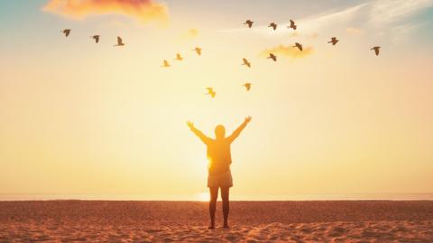 Woman standing at sunrise