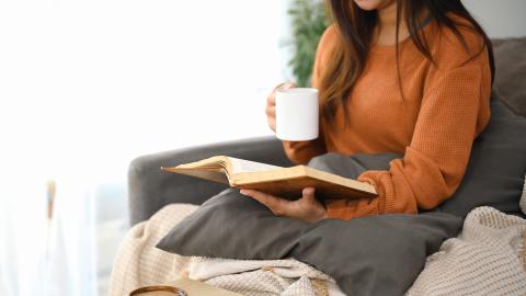 Woman reading Bible and drinking coffee