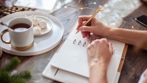 Woman writing and drinking coffee
