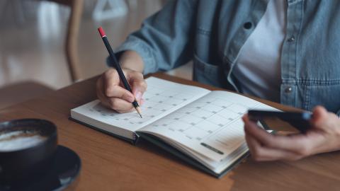 person looking at a calendar and phone